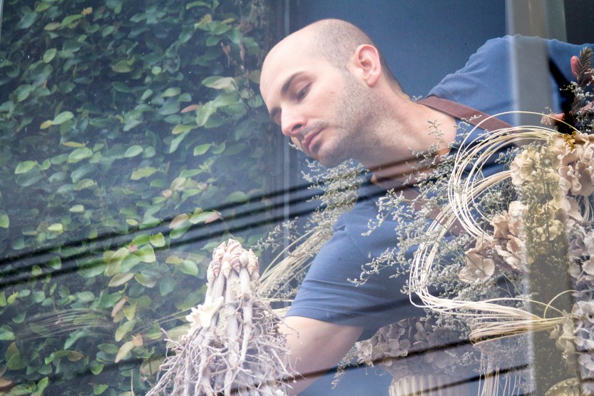 Artista floral Michel Benvenute montando a vitrine com a coleção litora escandinavo