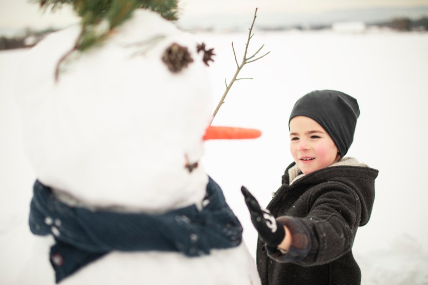 Kid Boy Making A Snowman