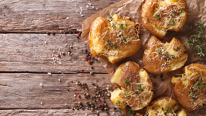 Rustic food: hot baked new potato with thyme on the table. horiz