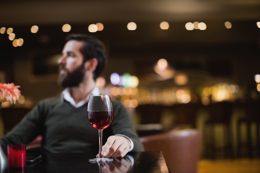 Man sitting with glass of wine in bar
